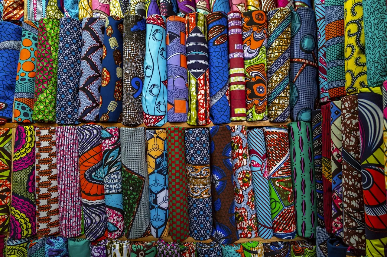 Tissus wax aux motifs afro-caribéens empilés sur un étal